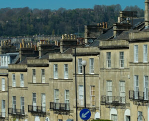 victorian townhouse or terrace in bath city in england united kingdom daytime down hill in a row brick style sunny day / victorian townhouse Bath in england
