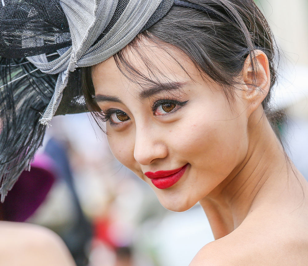 Lovely asian woman with a pretty hat at the Prix de Diane - The Prix de Diane is a French horse race which runs every year in June