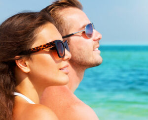 Happy Couple in Sunglasses having fun on the Beach. Summer Vacation