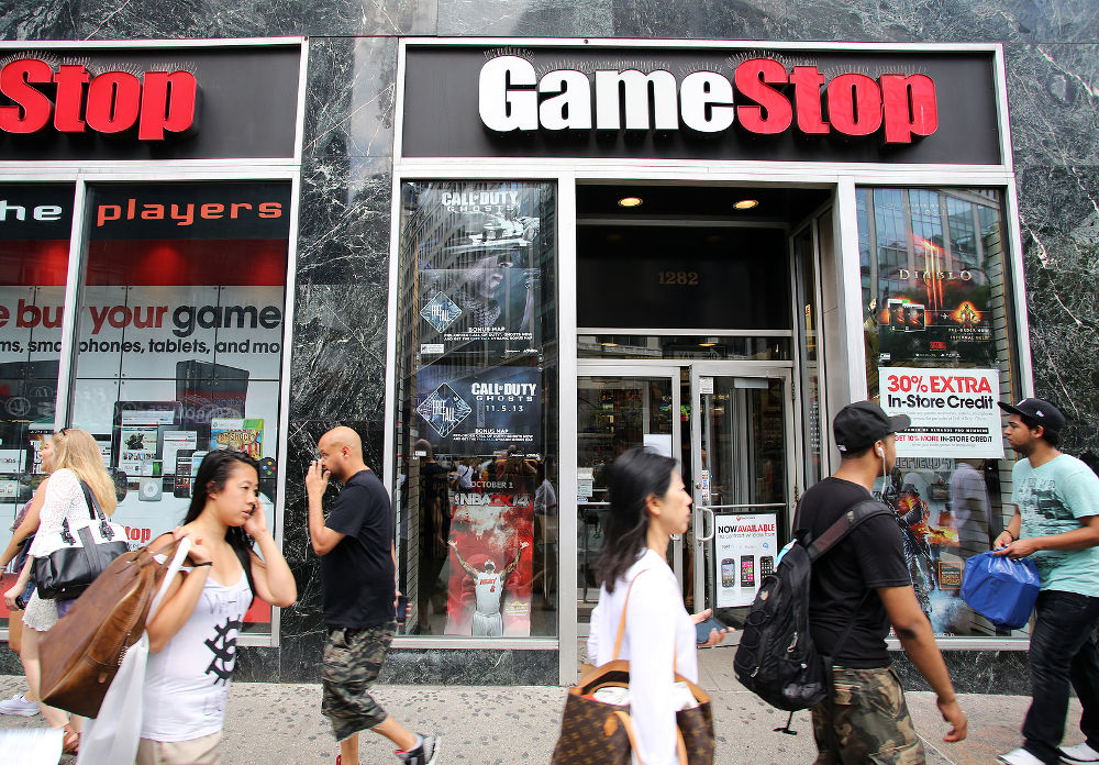 Shoppers walk past a GameStop retail store in New York City, New York