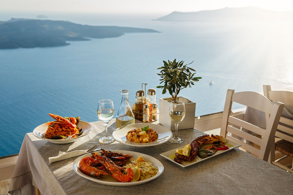 Romantic dinner for two at sunset.Greece, Santorini, restaurant on the beach, above the volcano.