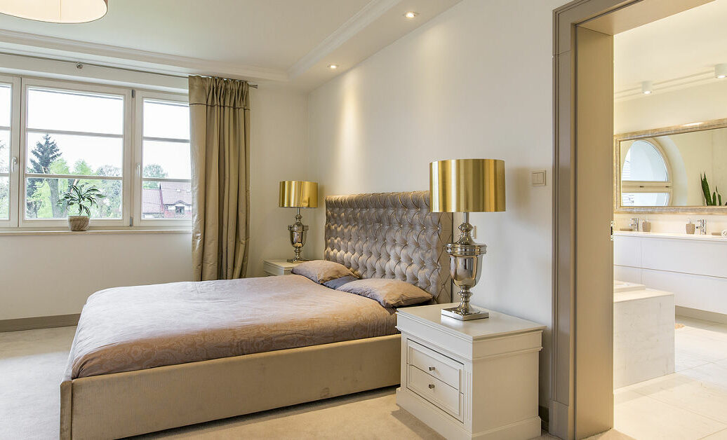 Very stylish bedroom suite with bathroom arranged in classic decorative style