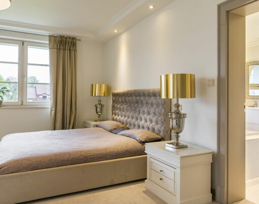 Very stylish bedroom suite with bathroom arranged in classic decorative style