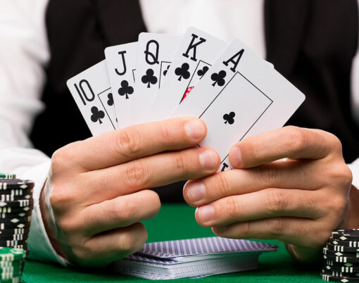 casino, gambling, poker, people and entertainment concept - close up of poker player with playing cards and chips at green casino table